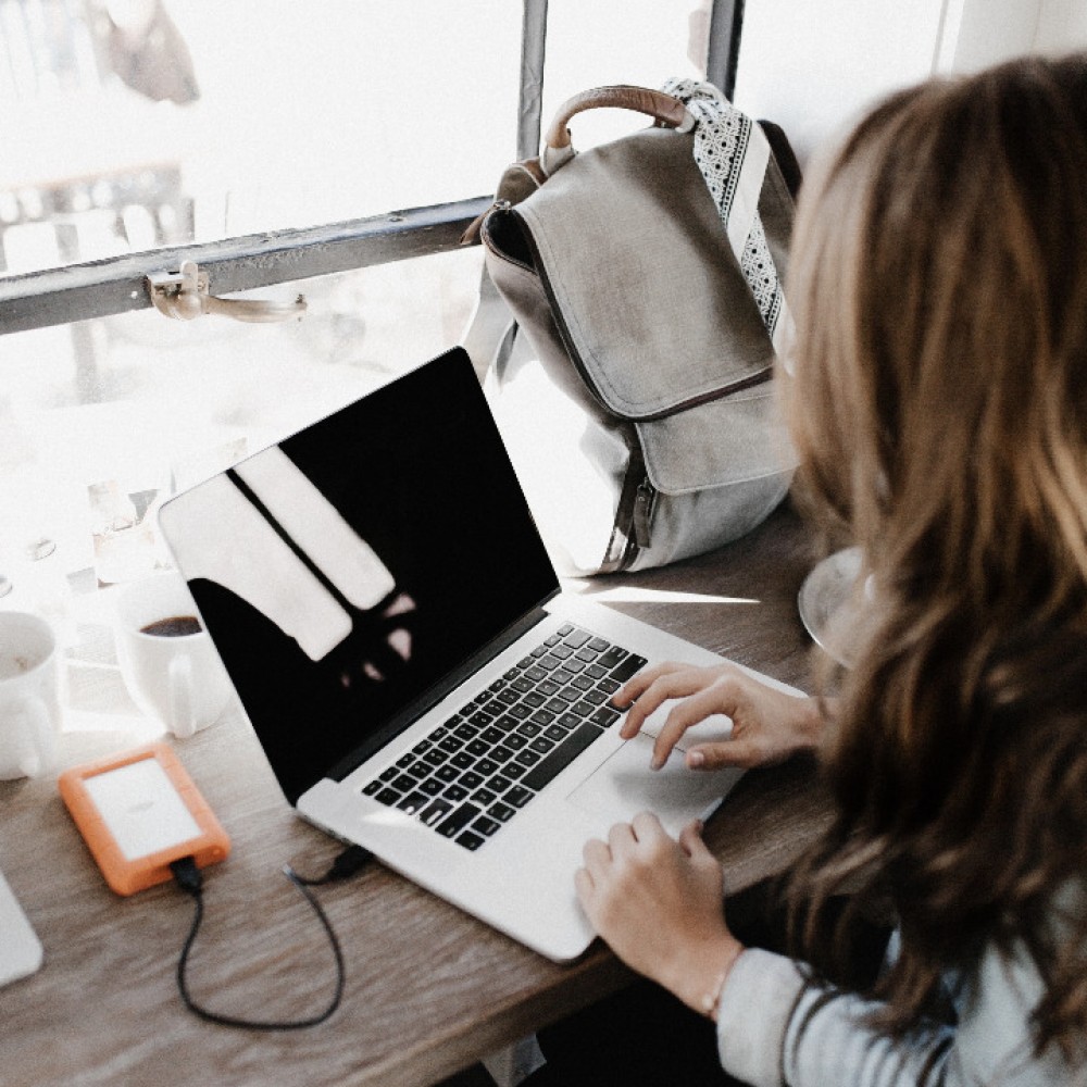Ondernemer maakt buiten kantoor gebruik van laptop om haar bedrijfsvoering op te volgen met eXopera online ERP 
